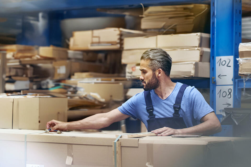 male busy with parcels in a distribution center/warehouse.
